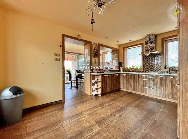 Eine Küche in einem Einfamilienhaus mit Holzmöbeln und Keramikfliesen.