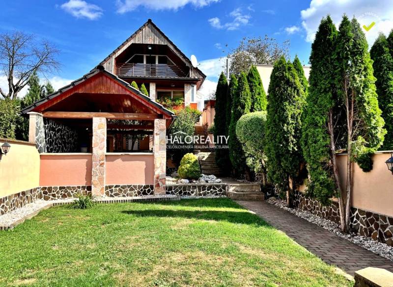 Ein Einfamilienhaus in Levice mit einem gepflegten Garten, einem Pavillon und Bäumen.