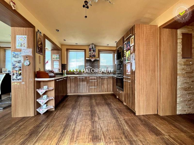 Küche in einem Einfamilienhaus mit Holzschränken und eingebauten Geräten.