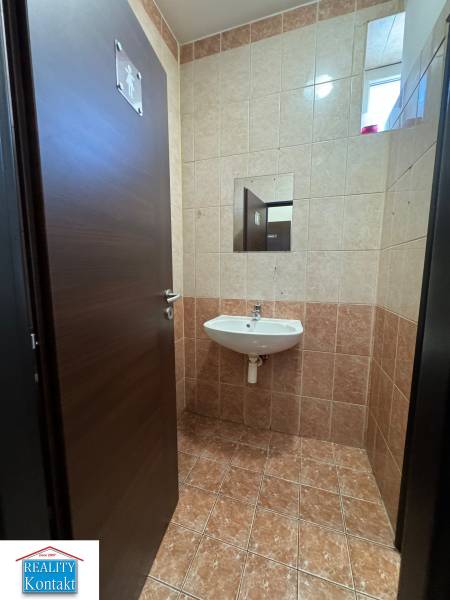 Toilette mit Waschbecken, gefliest in Geschäftsräumen.