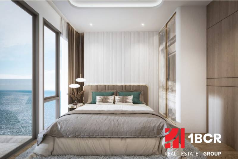 Helles Schlafzimmer mit großem Fenster und Meerblick in einer 3-Zimmer-Wohnung.
