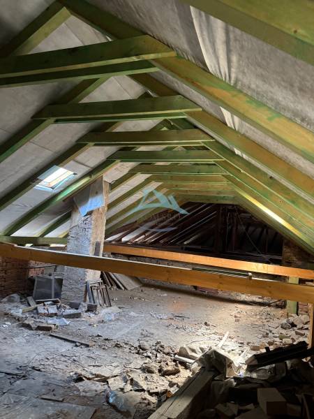 Decke von Geschäftsräumen mit Holzkonstruktion und Baumaterial, das über den Boden verstreut ist.