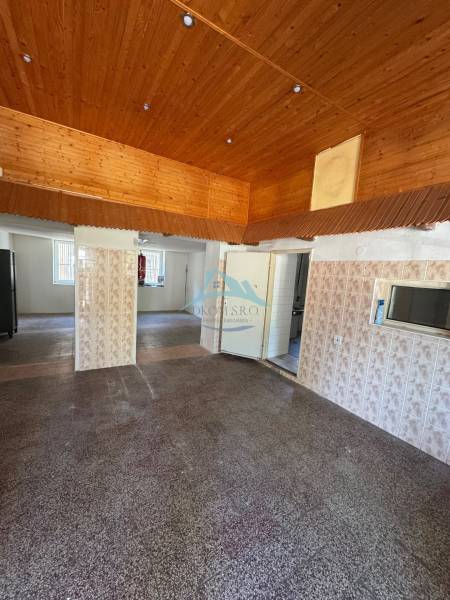 Holzdecke und geflieste Wand in Geschäftsräumen.
