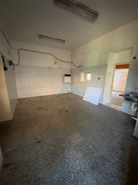 Innenraum von Geschäftsräumen mit älteren Verkleidungen und Fliesen, leerer Raum mit Waschbecken.