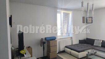 Wohnzimmer in einer 2-Zimmer-Wohnung mit Sofa und Fernseher, Zertifikat eines geprüften Büros.