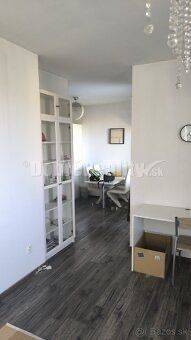 Interieur einer 2-Zimmer-Wohnung mit dunklem Boden und weißen Möbeln.