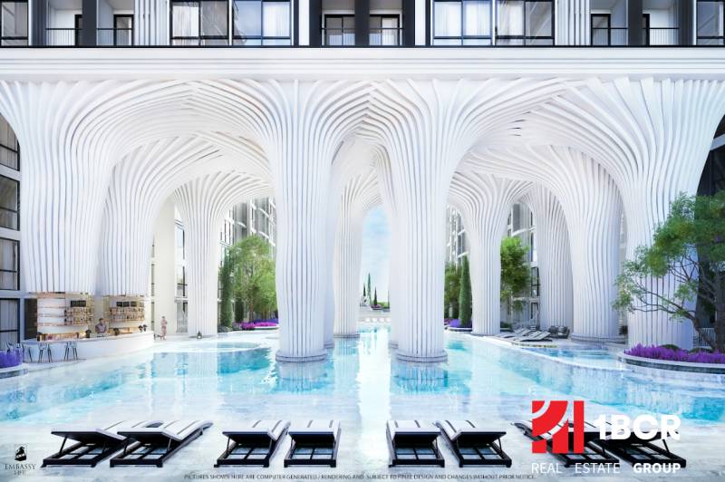 Luxuriöse Wohnbebauung mit Pool und weißen Säulen, die an futuristische Architektur erinnert.