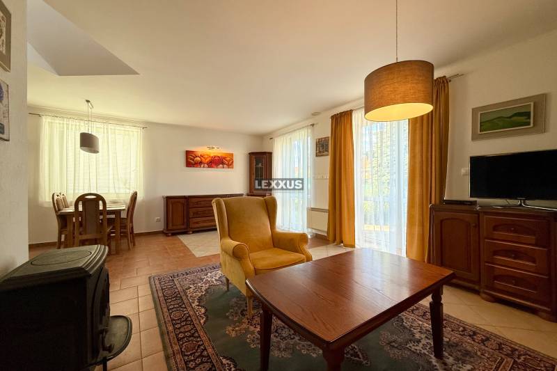 Wohnzimmer in einem Einfamilienhaus mit einem bequemen Sessel, Fernseher und Esstisch.