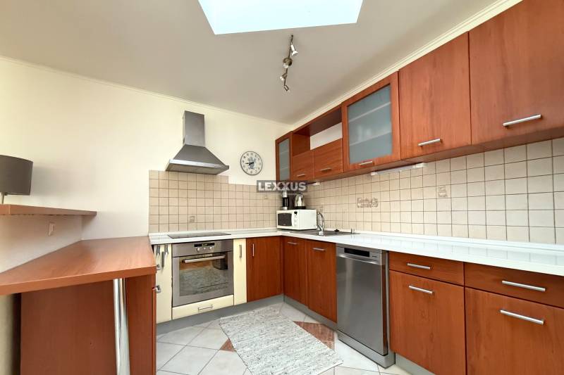 Küche in einem Einfamilienhaus mit Holzschränken, Geschirrspüler und Keramikfliesen an der Wand.