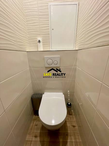 Toilette mit Fliesen und Boden in einer 4-Zimmer-Wohnung, helle Farben verleihen ein sauberes Aussehen.