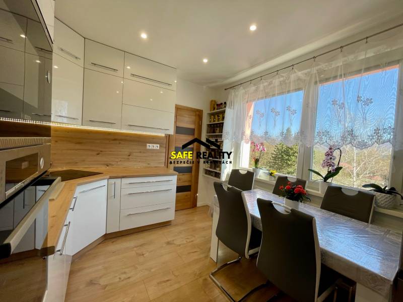 Küche in einer 4-Zimmer-Wohnung mit hellen Möbeln und Esstisch.