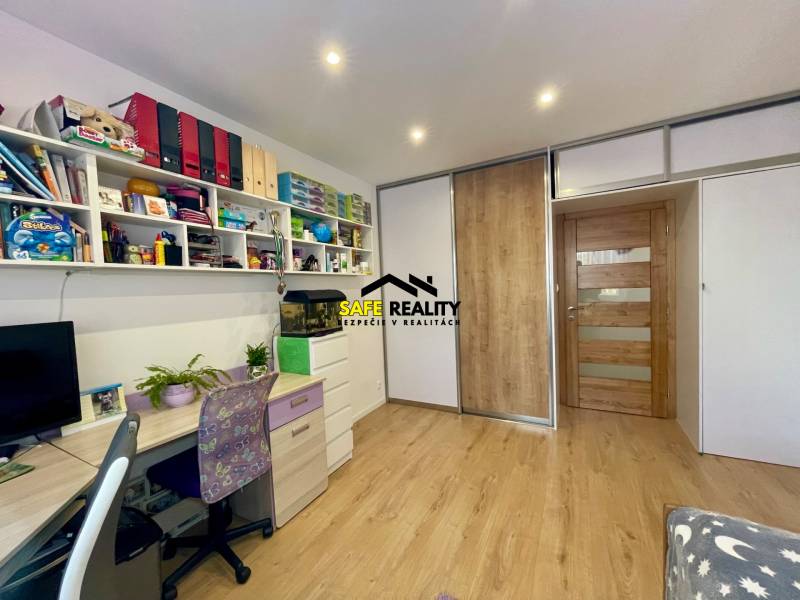 Kinderzimmer in einer 4-Zimmer-Wohnung mit Arbeitsecke und Regalen.
