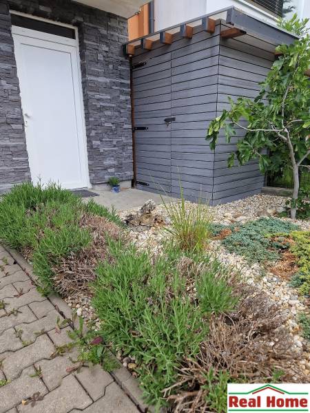 Garten mit Blumen und Pflastersteinen bei einem Einfamilienhaus in der Brusnicova-Straße in Chorvátsky Grob.