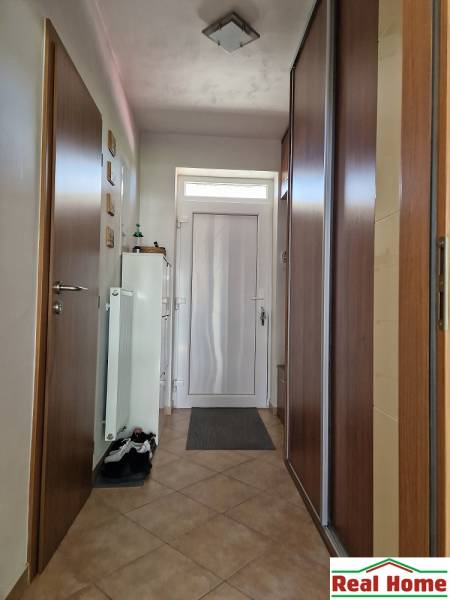 Eingangsflur in einem Einfamilienhaus mit Fliesenboden und Einbauschrank.