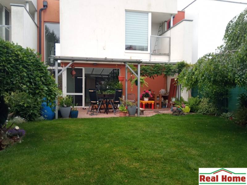Der Garten des Einfamilienhauses in der Brusnicova-Straße in Chorvátsky Grob mit Terrasse und Grünflächen.