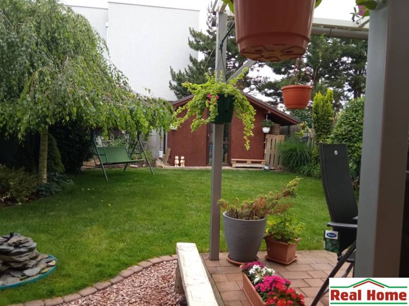 Garten bei einem Einfamilienhaus in der Brusnicová-Straße in Chorvátsky Grob mit Schaukel und Pavillon.