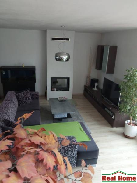 Wohnzimmer in einem Einfamilienhaus mit Kamin, Sitzgruppe und Dekorationen.