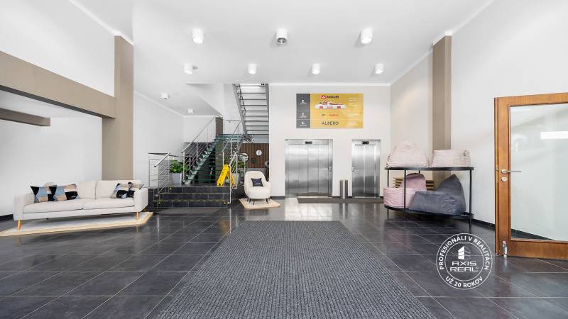 Empfangsbereich mit Sofa, Aufzügen und Treppenhaus in Geschäftsräumen.