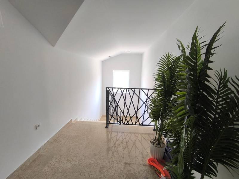 Treppe mit Blumentöpfen und Geländer in einer 4-Zimmer-Wohnung.