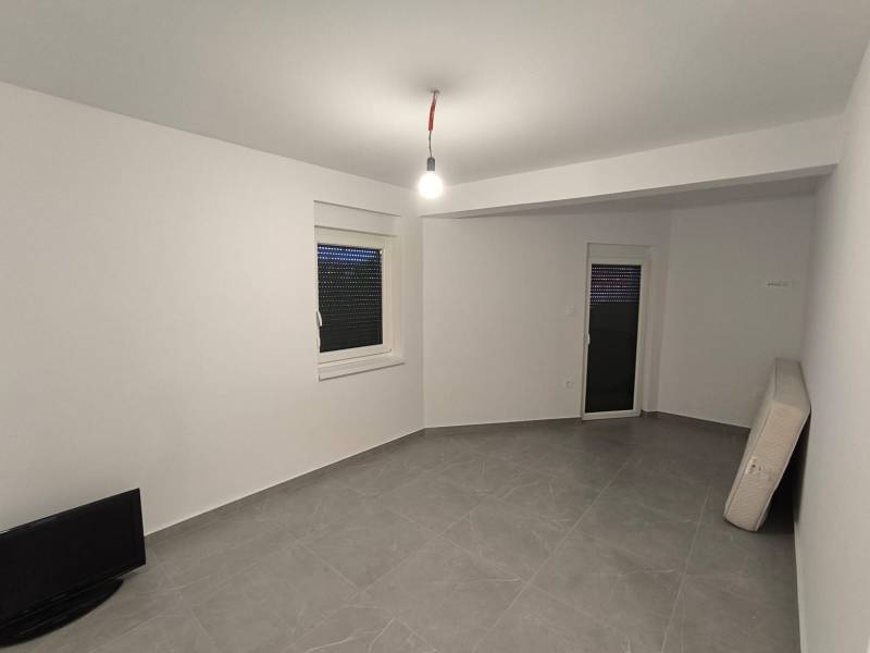 Stilvolles Zimmer einer 4-Zimmer-Wohnung mit Fernseher und Matratze auf dem Boden.