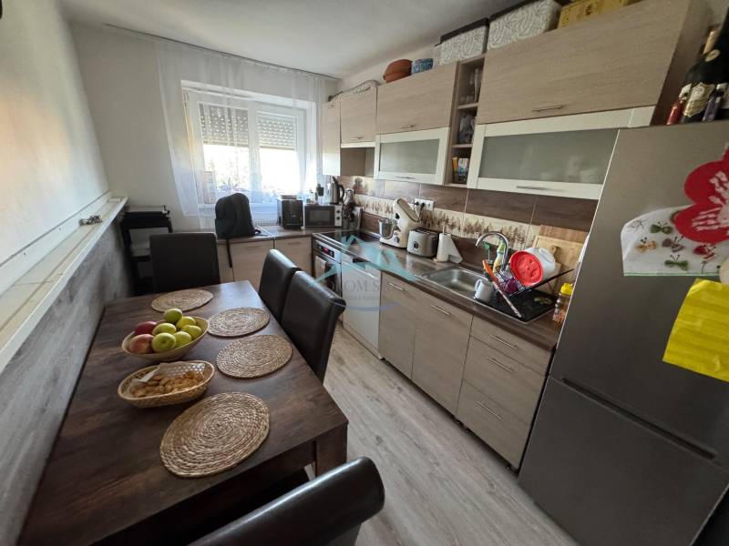 Küche in einer 3-Zimmer-Wohnung mit Tisch, Stühlen und moderner Ausstattung in angenehmem Licht.