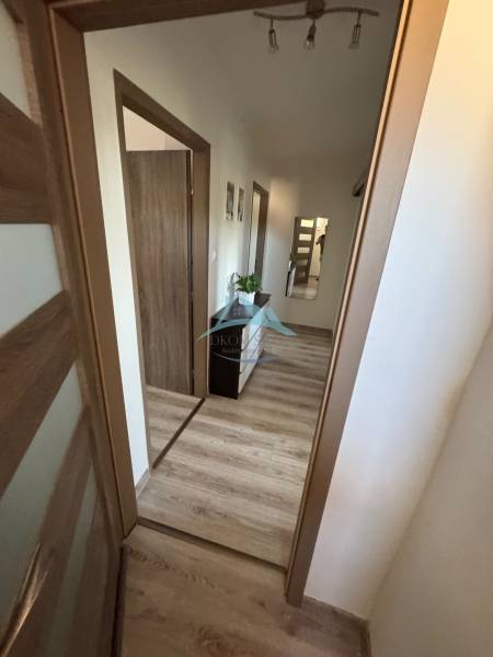Der Flur einer 3-Zimmer-Wohnung mit Holzboden und Eingängen zu den Räumen.