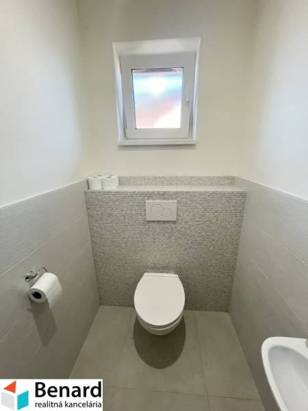 Badezimmer in einem Einfamilienhaus mit Keramikfliesen und Toilette.