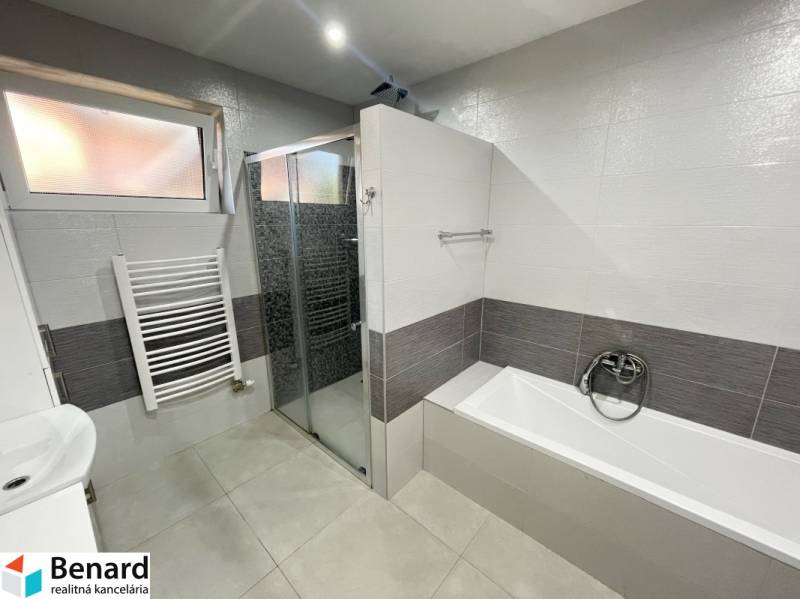 Badezimmer mit Badewanne und Dusche in einem Einfamilienhaus.