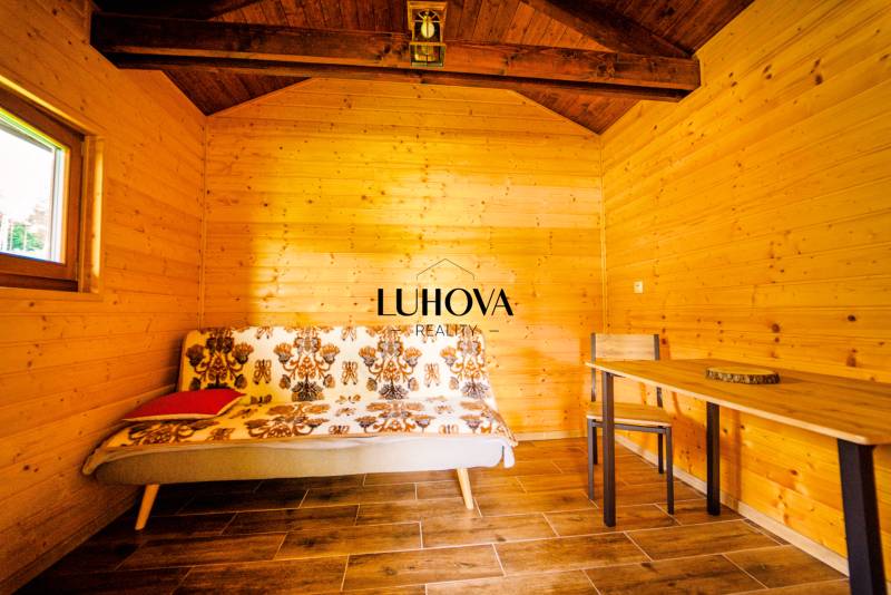 Ein hölzernes Interieur mit einem Sofa und einem Tisch in einer malerischen Hütte auf einem Grundstück - Wohnen.