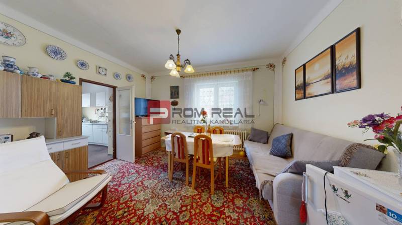 Wohnzimmer in einem Einfamilienhaus mit Sofa, Esstisch und Wanddekorationen.