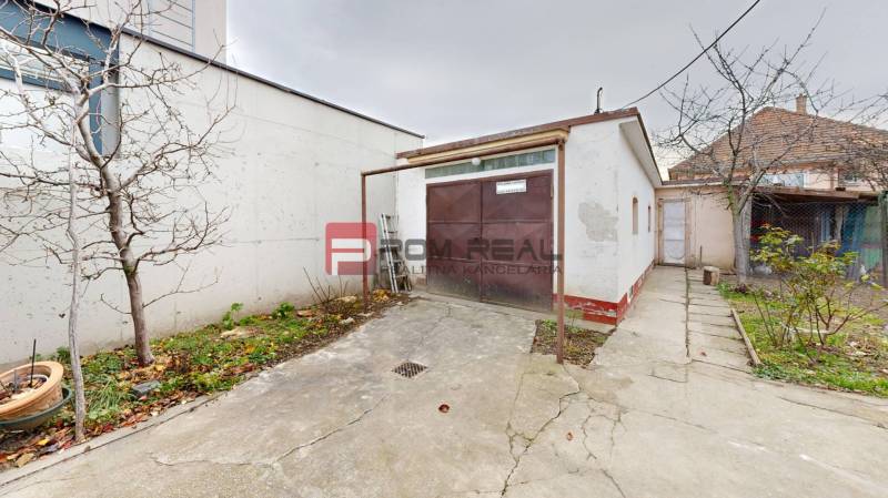 Hof bei einem Einfamilienhaus in der Farebná-Straße in Bratislava II mit Garage und Bäumen.