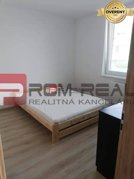 Einfaches Schlafzimmer mit Licht, Bett und Möbeln in einer 2-Zimmer-Wohnung in der Slavomírova-Straße.