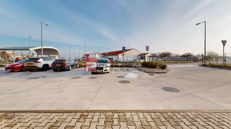 Parkplatz in der Obchodná-Straße in Pezinok mit mehreren geparkten Autos.
