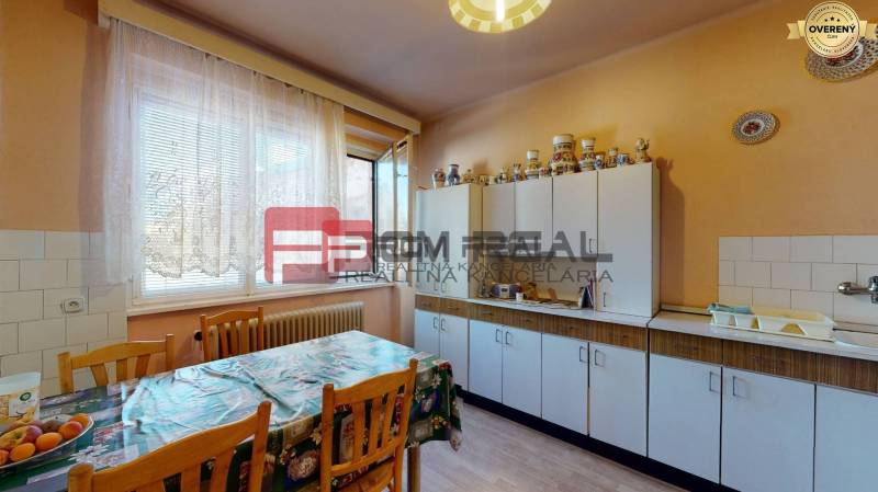Küche mit weißen Schränken, Esstisch und Dekorationen in einem Einfamilienhaus.