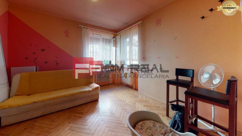 Wohnzimmer in einem Einfamilienhaus mit Sofa, Stühlen und Ventilator.