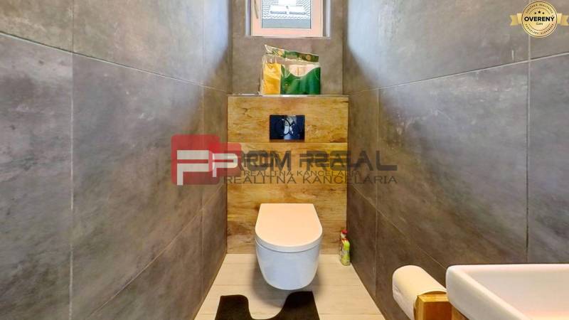 Badezimmer im Einfamilienhaus mit Toilette, Waschbecken und Stauraum.
