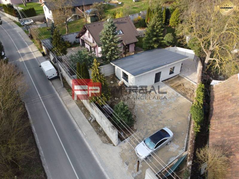Einfamilienhaus in Pezinok mit Garten und Zufahrtsweg, mit Auto im Hof.
