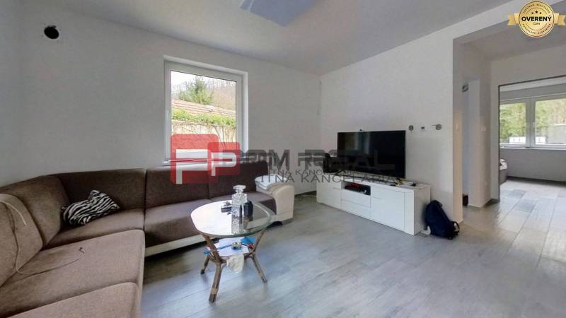 Wohnzimmer mit Ecksofa, Couchtisch und Fernseher in einem Einfamilienhaus.