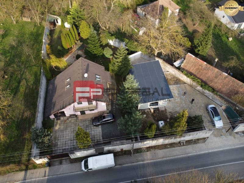 Ein Einfamilienhaus in Píla mit Garten, Zufahrtsstraße und Parkplatz, umgeben von Grün.