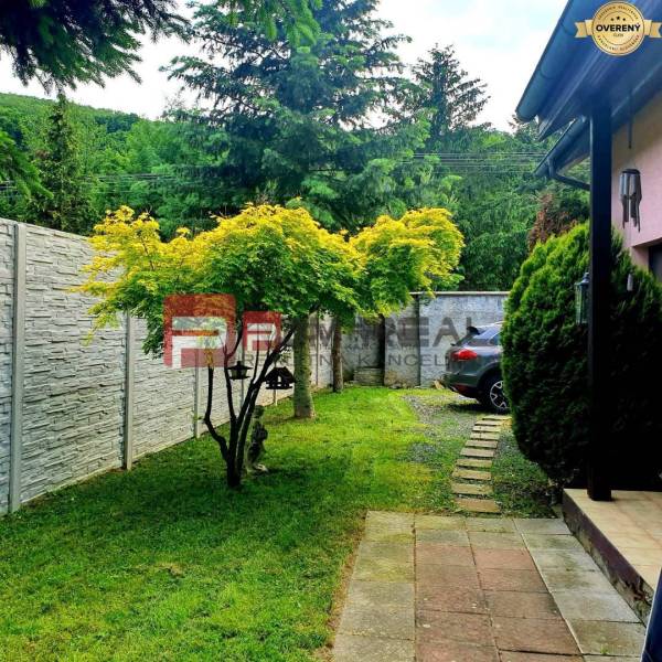 Ein Einfamilienhaus in der Gemeinde Píla mit Garten, Auto und einzigartigen Bäumen.