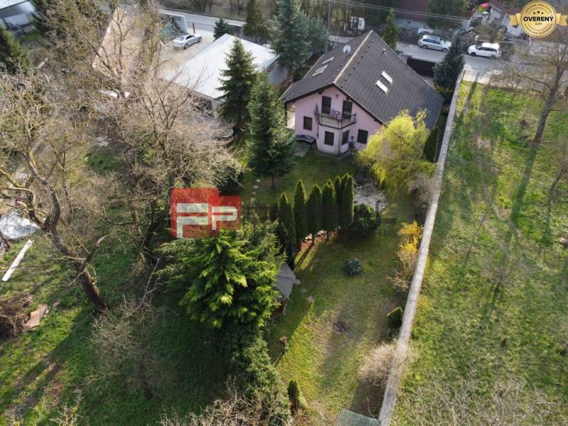 Ein Einfamilienhaus in Píla, umgeben von Bäumen, mit einem gepflegten Garten und benachbarten Gebäuden.