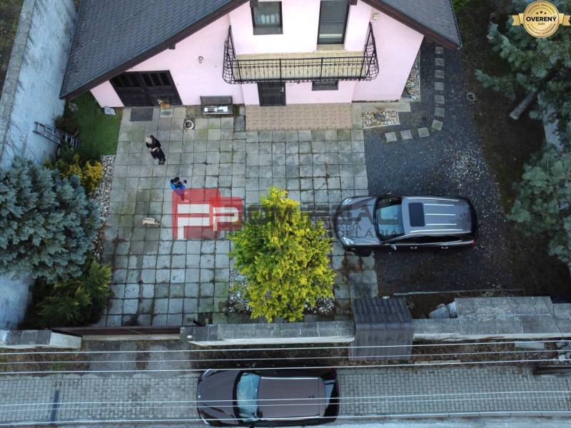 Ein Einfamilienhaus in Píla mit einem geräumigen Hof, geparkten Autos und einem gepflegten Garten.