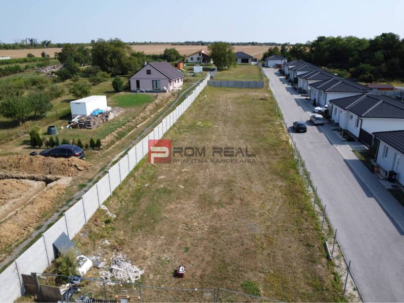 Grundstücke - Wohnen in Štefanová, neben einer leeren Parzelle, umgeben von ländlichen Häusern und Grünflächen.