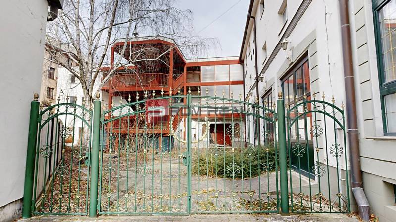 Der Garten vor dem Gebäude in der Ľ. Podjavorinská-Straße in Trnava, mit einem grünen Metallzaun.