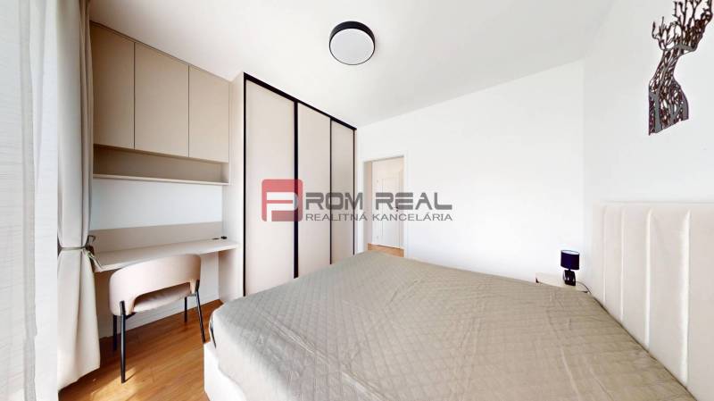 Schlafzimmer in einer 2-Zimmer-Wohnung mit Bett, Kleiderschrank und Schreibtisch.