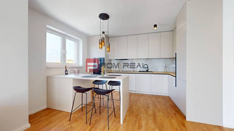Küche in einer 2-Zimmer-Wohnung mit Bartresen, Stühlen und eingebauten Geräten.