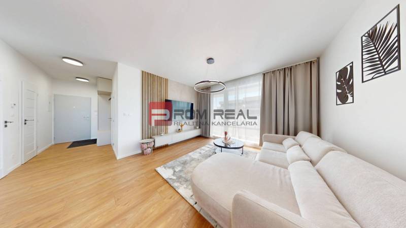 Helles Wohnzimmer mit Sofa und Fernseher in einer Zweizimmerwohnung.