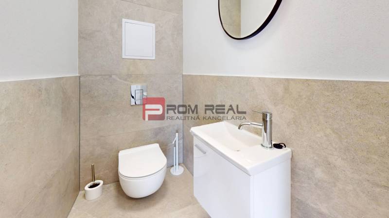 Badezimmer in einer 2-Zimmer-Wohnung mit Toilette, Waschbecken und Spiegel.