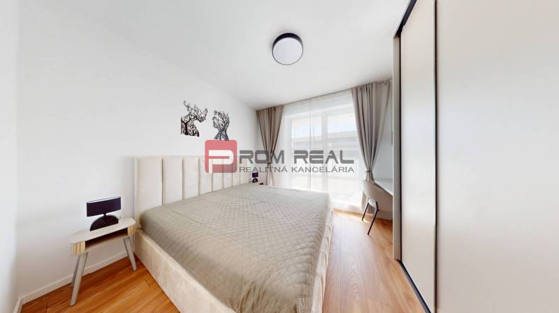 Helles Schlafzimmer in einer 2-Zimmer-Wohnung mit großem Bett und Einbauschrank.