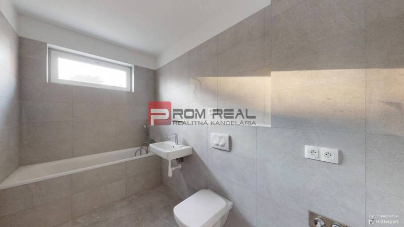 Badezimmer in einer 2-Zimmer-Wohnung mit Badewanne und Waschbecken in neutraler Farbgestaltung.